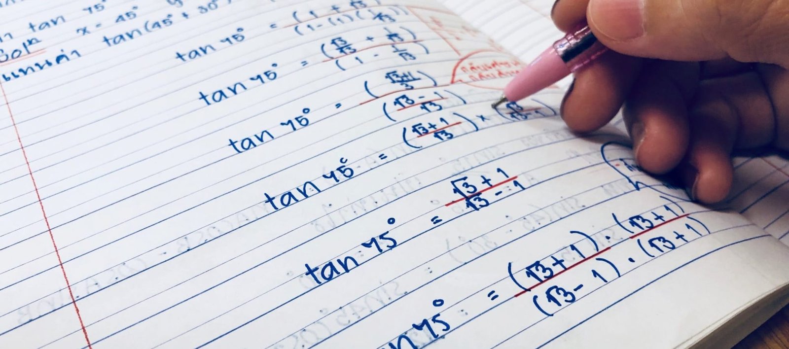 Closeup people hand doing mathematics homework at home